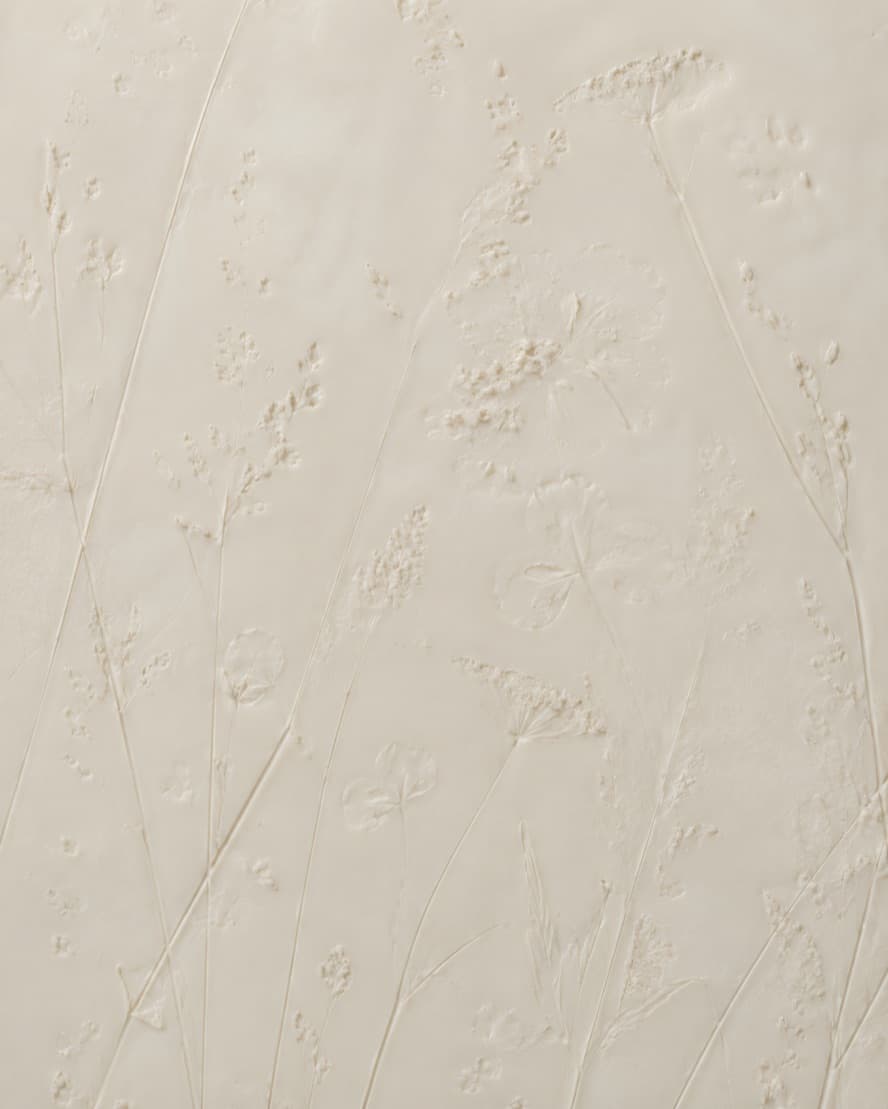 Pale wax holding the raised impressions of grass stems and umbel flower heads